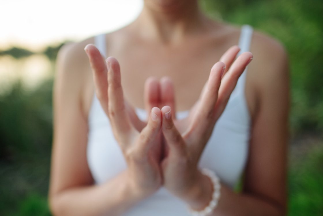 Hands forming Padma Mudra, the lotus gesture, symbolising heart opening, compassion, and inner stillness in a meditative practice.