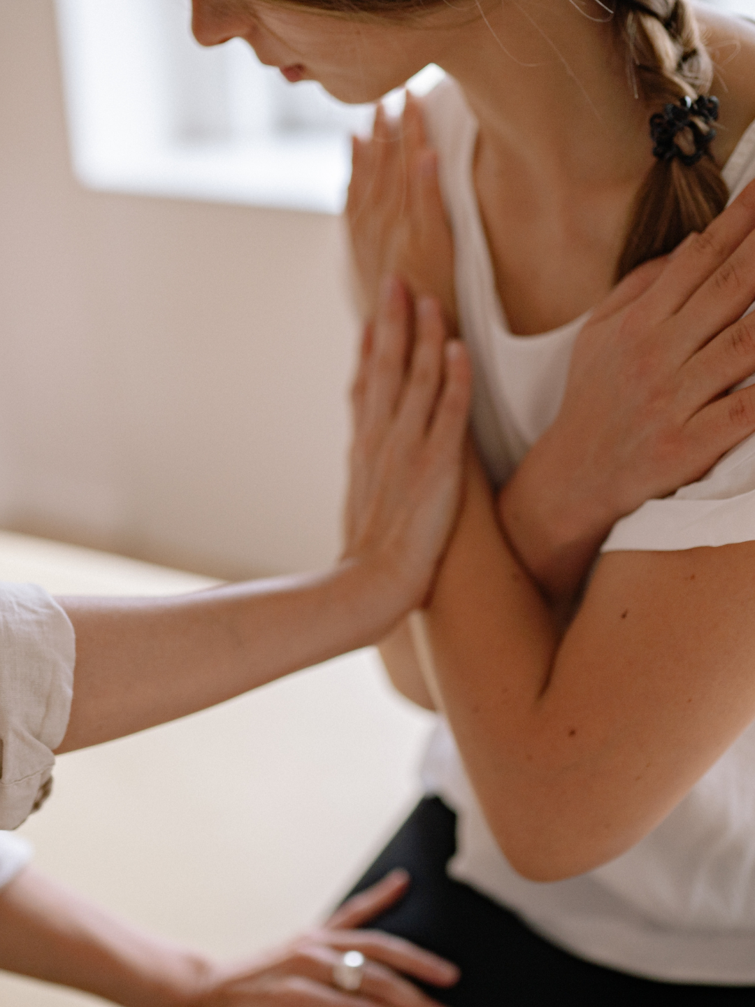 A practitioner’s hand gently touching the body during a massage, supporting relaxation, release of tension, and overall wellbeing.