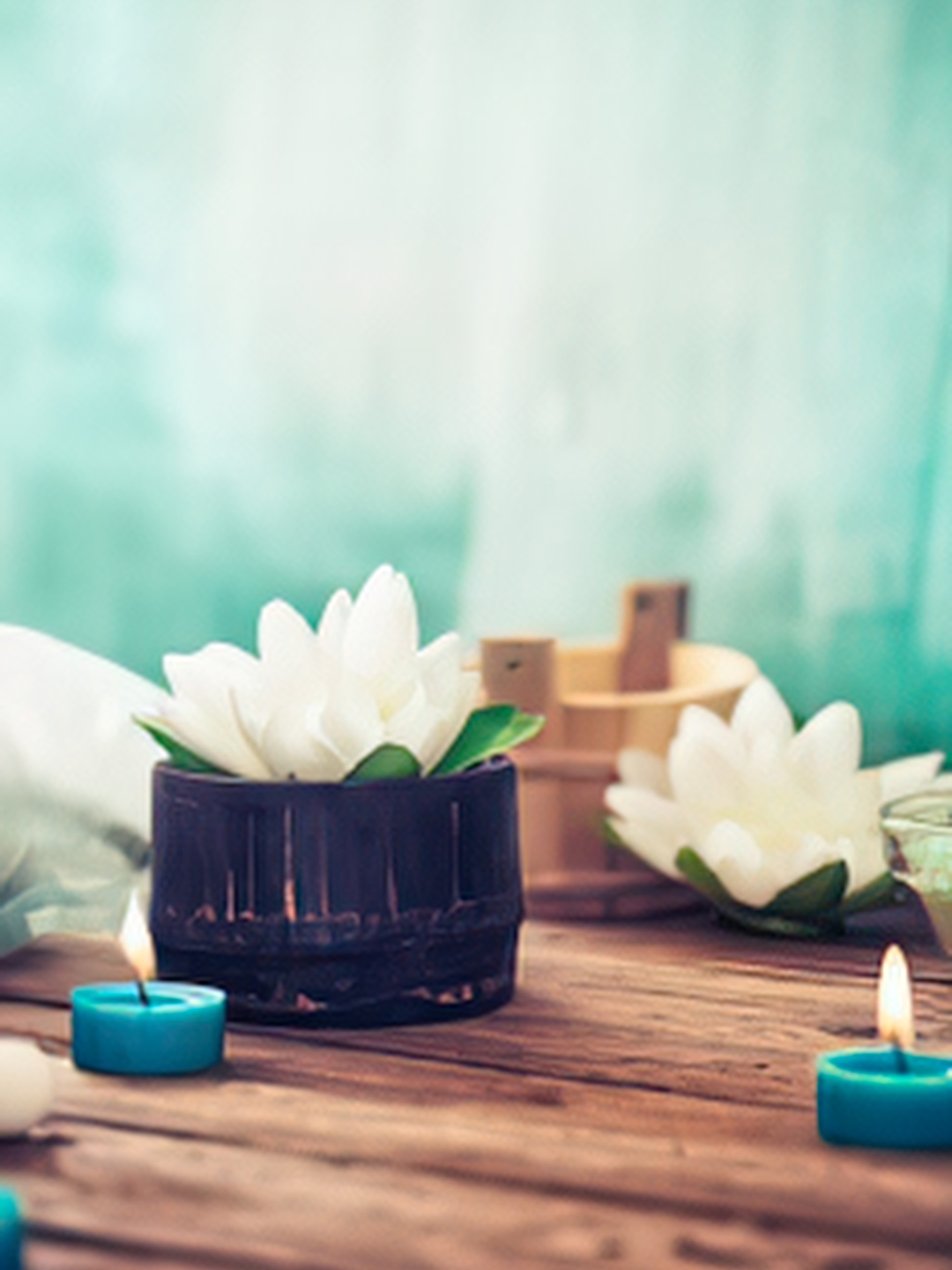 Lotus flowers and lit candles creating serene environment for yoga, massage and Reiki