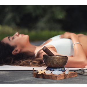 A person lying comfortably in savasana during a Yoga Nidra session, resting deeply with eyes closed.