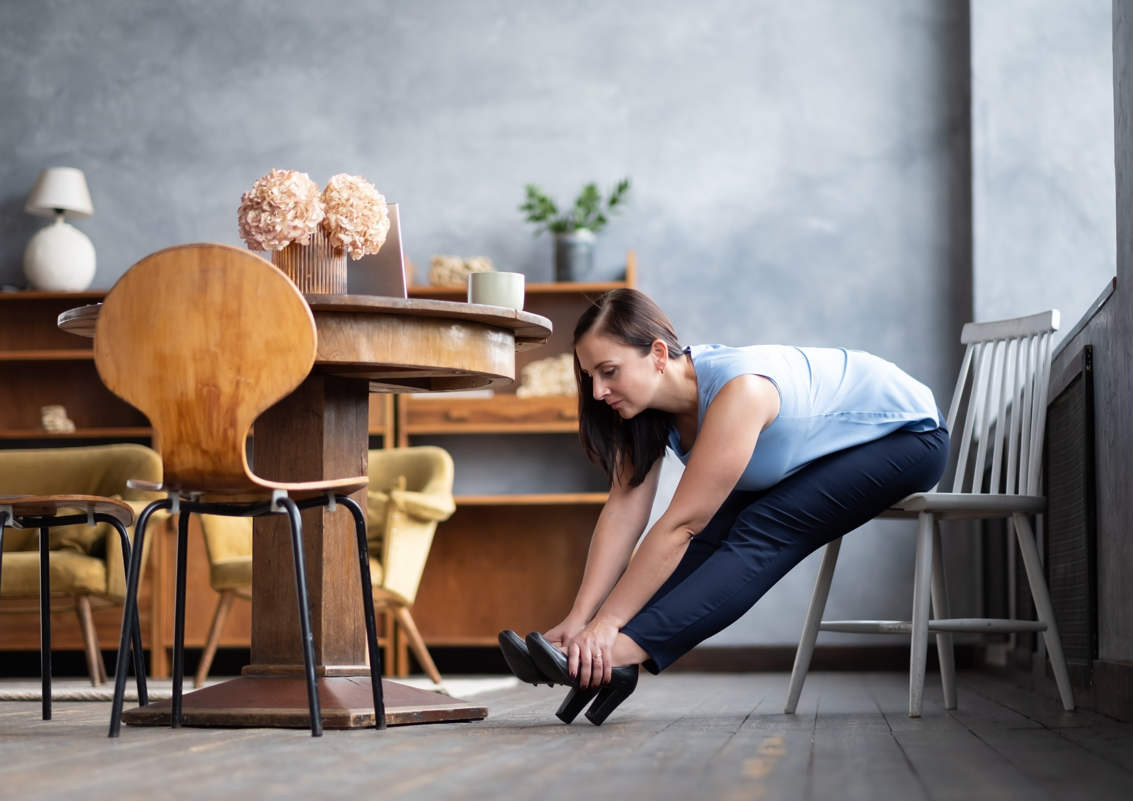 A women performing a hamstring and hip stretch on a chair