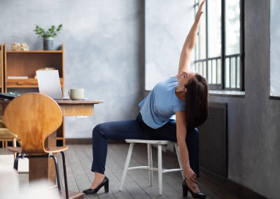 Office woman performing a deep hips stretch on a chair