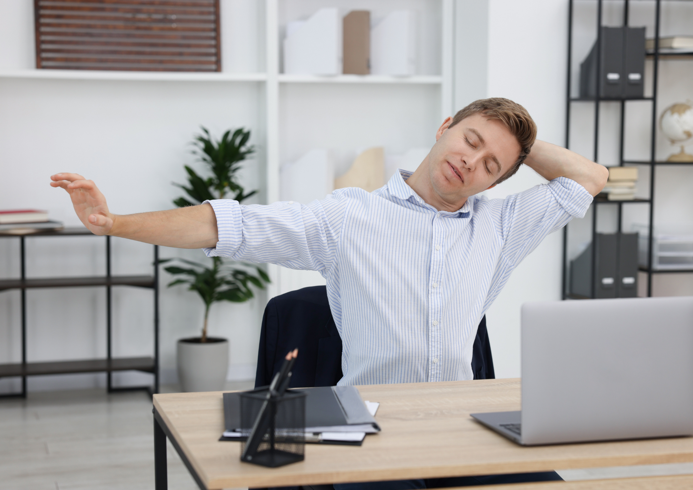 A man doeing a seated stretch to release tension in shoulders and nreck