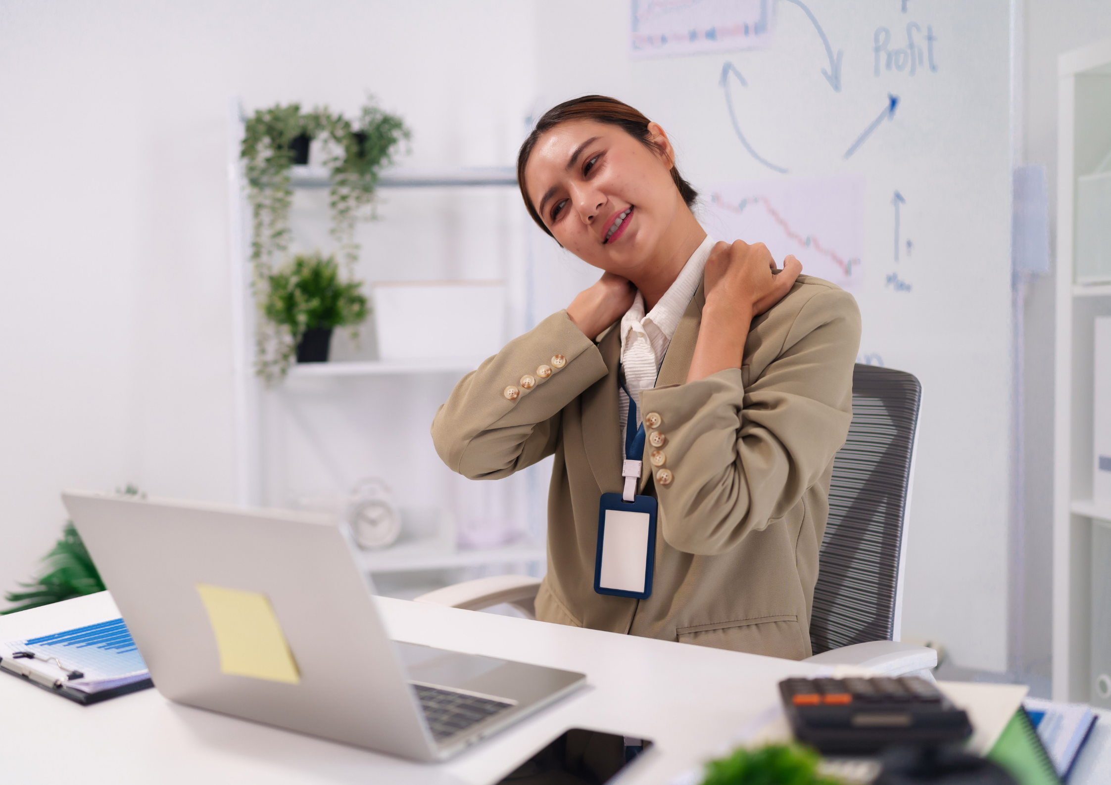 Person sitting at a desk experiencing neck and shoulder discomfort caused by poor posture and prolonged sitting.