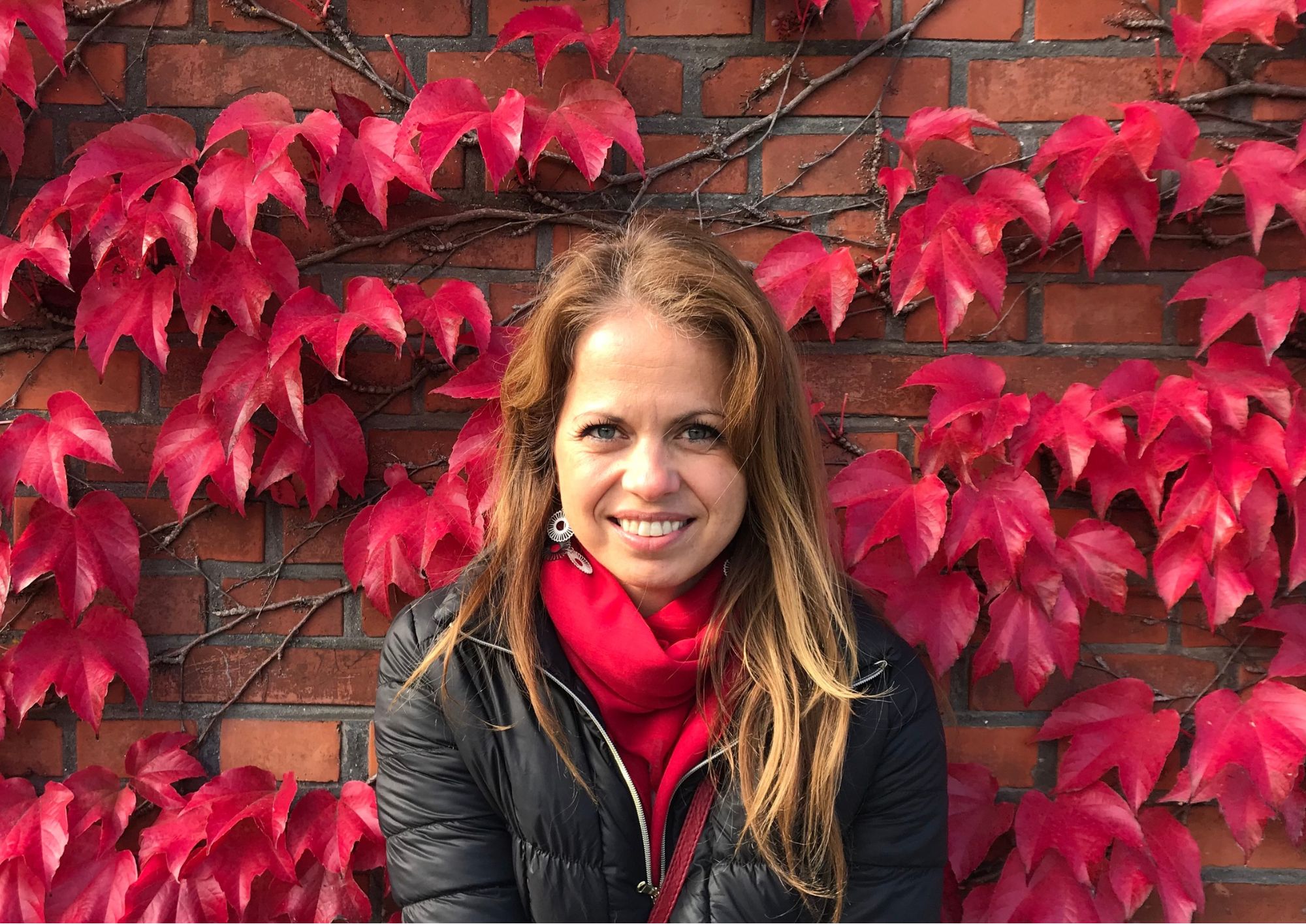 Woman with a background of autumn leaves, connected to nature, reflecting on yoga, healing, mindfulness, and holistic wellbeing.
