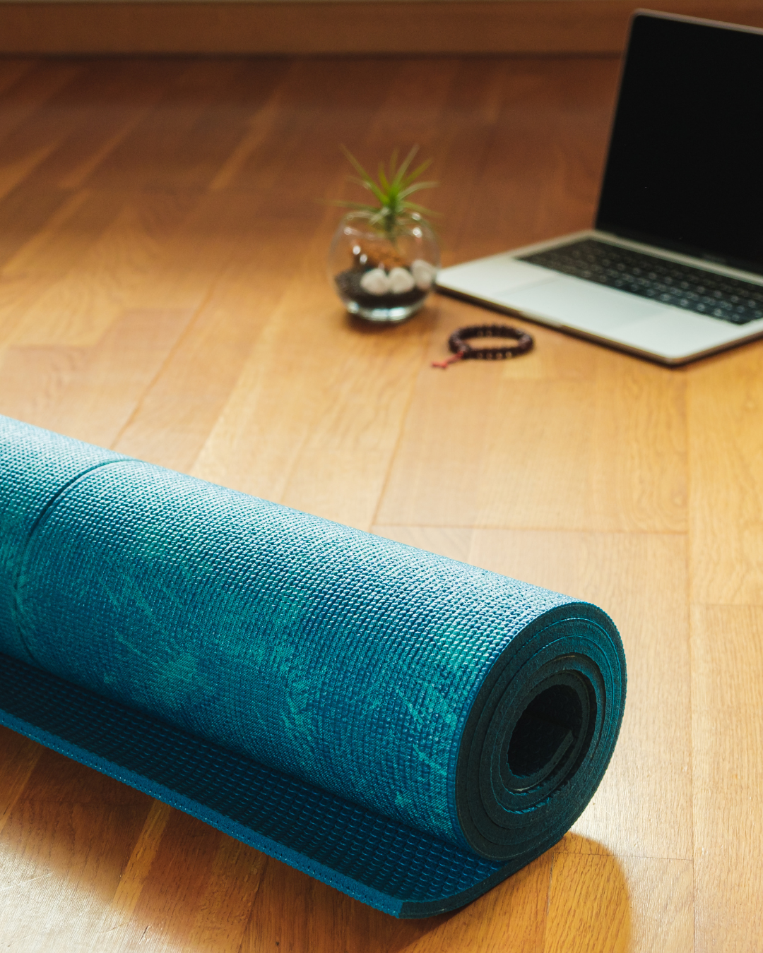 A yoga mat in front of a laptop for online yoga practice 